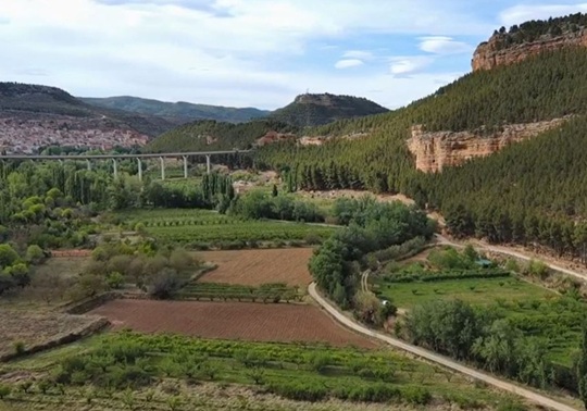 Imatge panoràmica de la vega del municipi d'Ademús on es veu el pont carretera que creua
